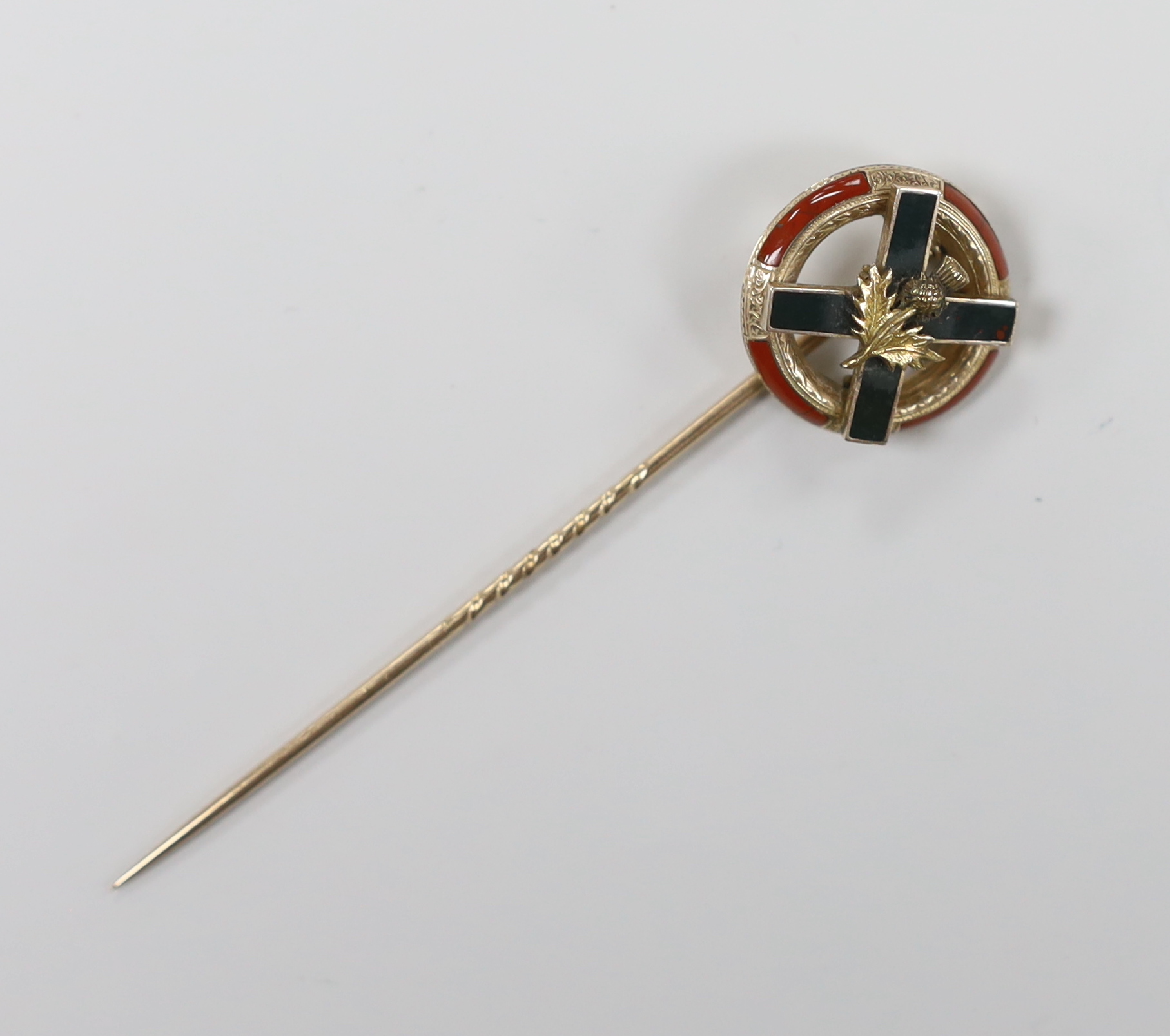 An early 20th century yellow metal and Scottish hardstone set stick pin, with St Andrew's cross and thistle, 8cm overall